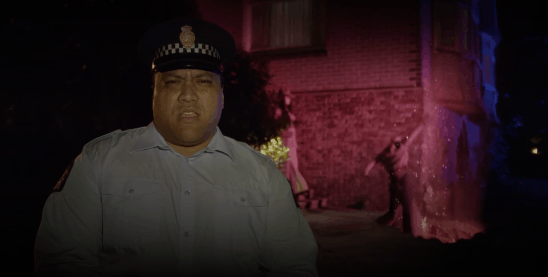 Sergeant Maaka stands outside a ghost house in Wellington Paranormal