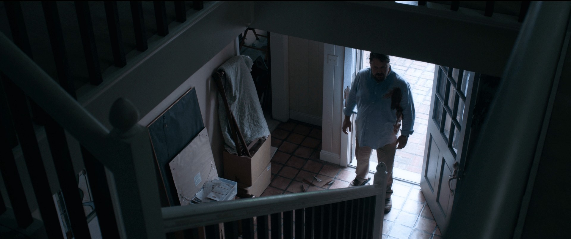 A staircase scene from the film Unhinged. Normally, high angle shots make a character look less powerful, but in the case of villains entering your hallway, this effect becomes inverted.